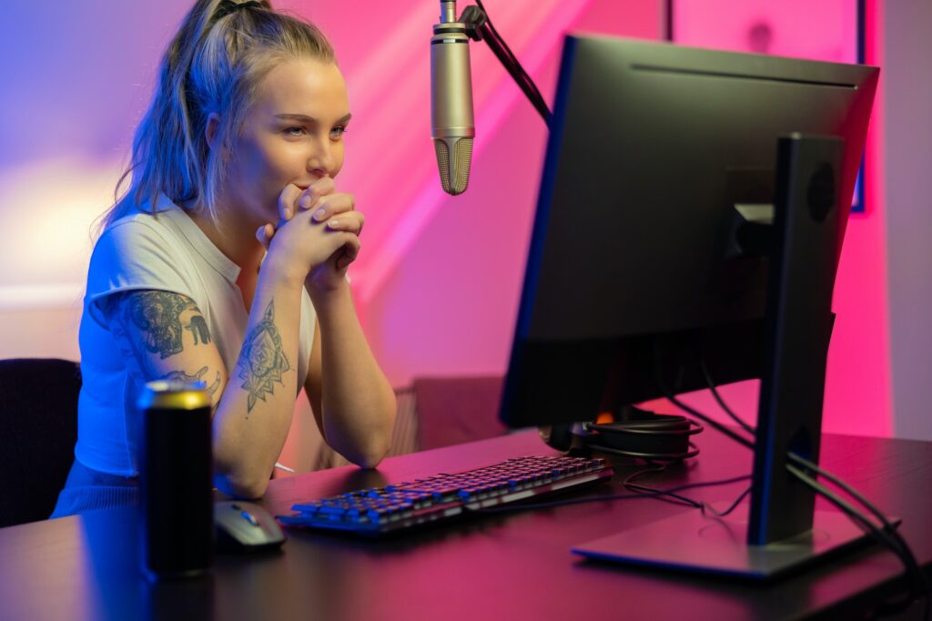 Beautiful professional gamer girl live streaming and play online multiplayer video game on PC - social media content marketing to increase traffic